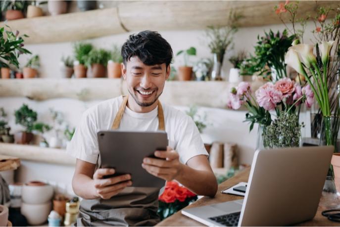 Merchant on a tablet in a flower shop.